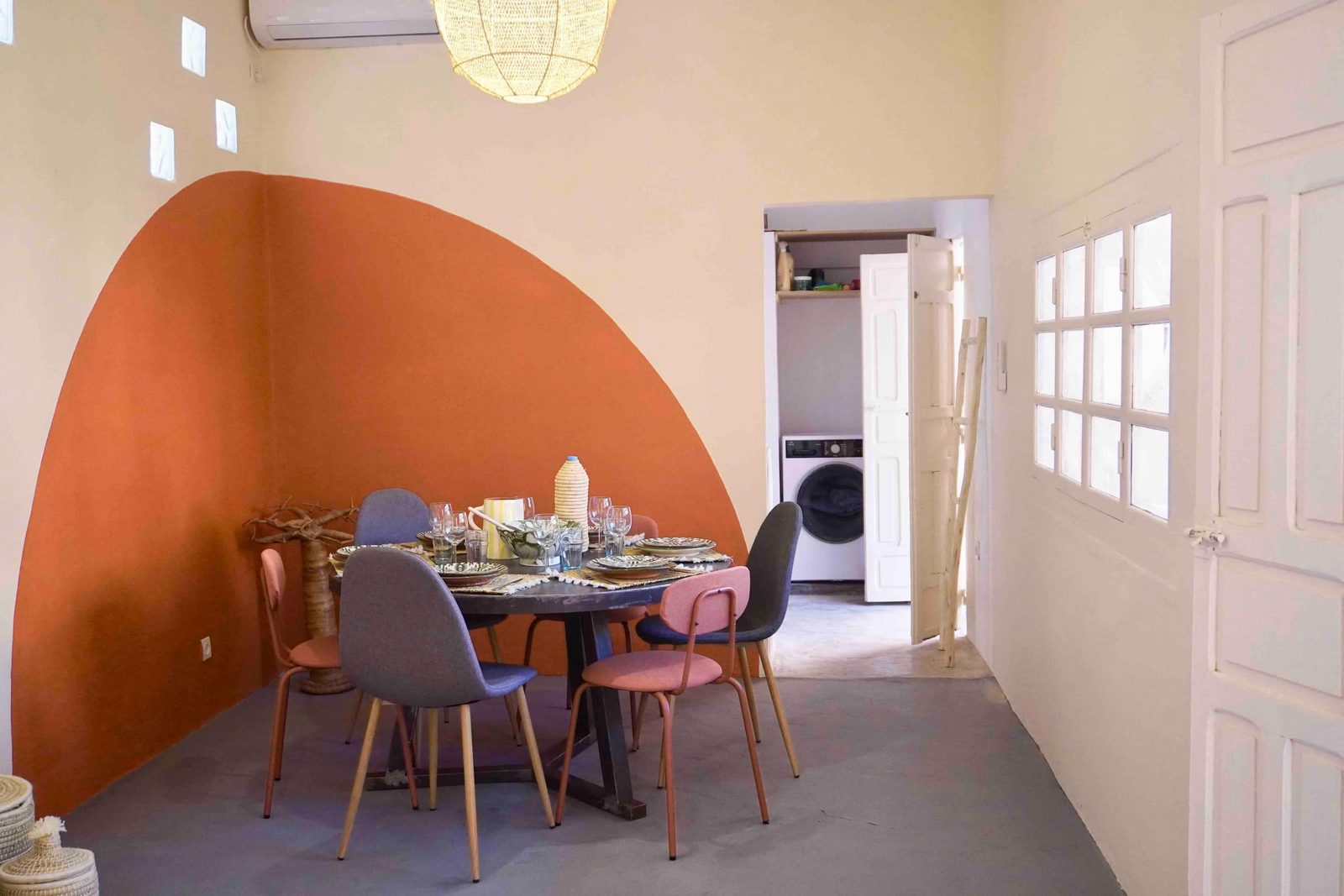La salle à manger de Dar Djinou, table dressée sous l’arche peinte terracotta